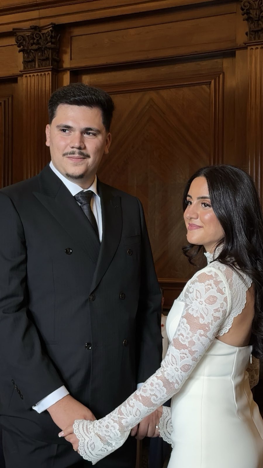 Bride and groom hand in hand at their London register office wedding