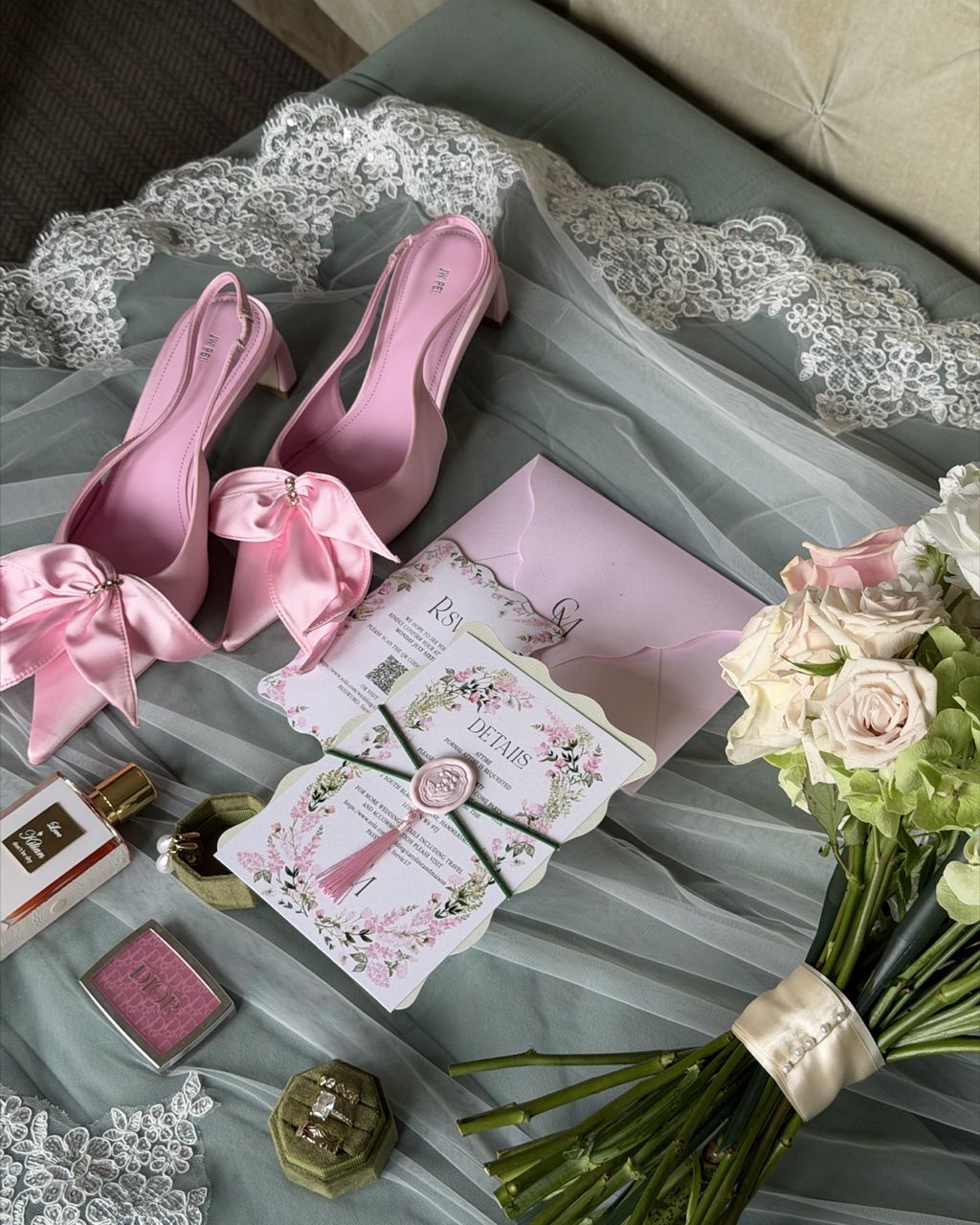 Pink bridal shoes, wedding stationery and bouquet laid out on the morning of the wedding